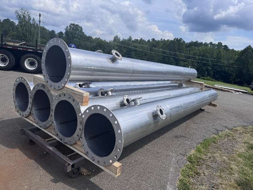 Fabricated exhaust stacks with flanged ends staged for shipment